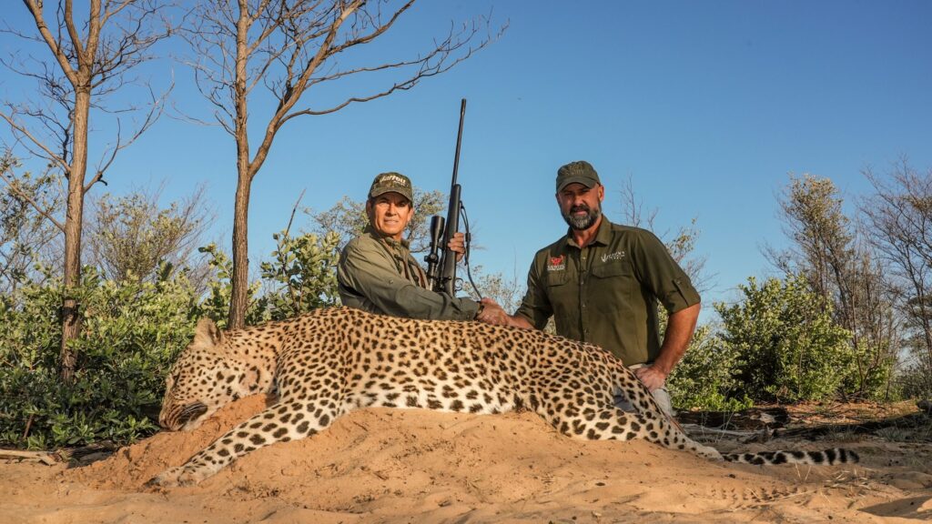 A hunter and professional hunter with a leopard